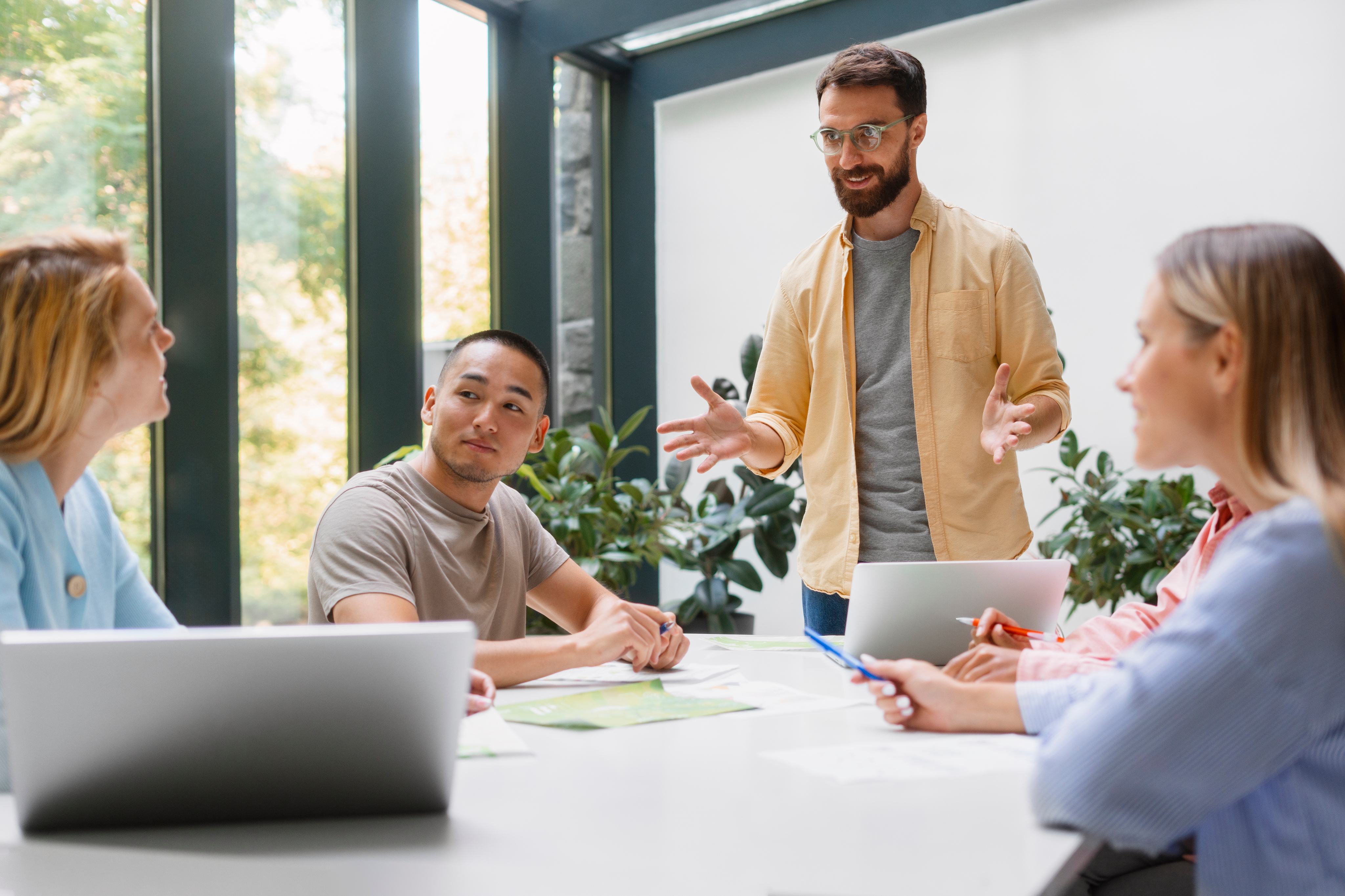 Man talking to a table of coworkers
